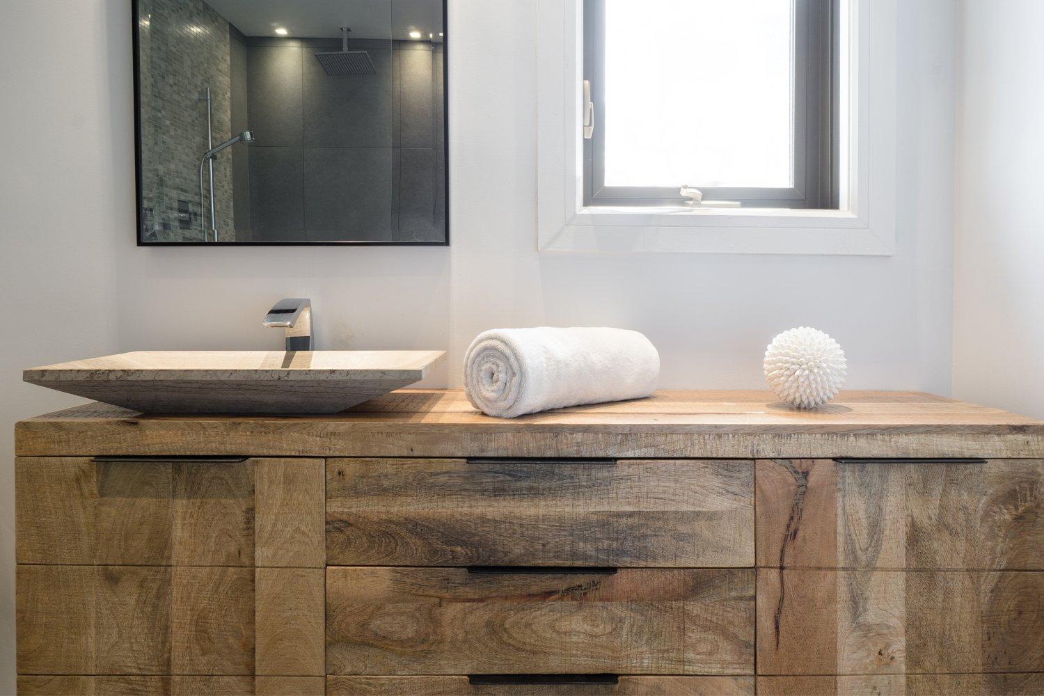 Bathroom with reclaimed wood-look vanity and stone vessel sink