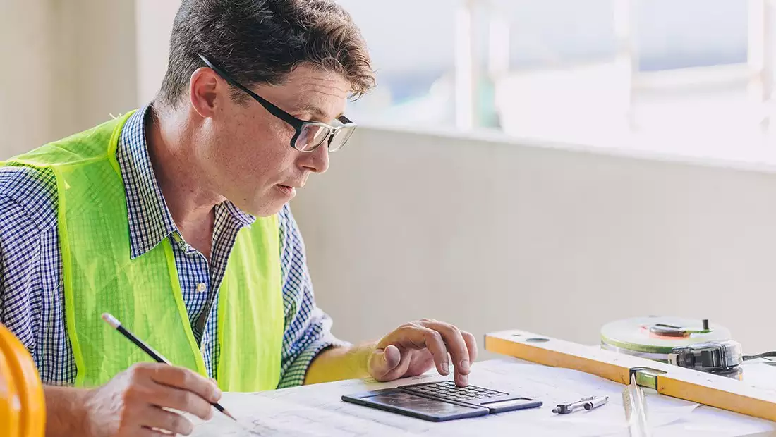 Contractor Working on Budget with Calculator