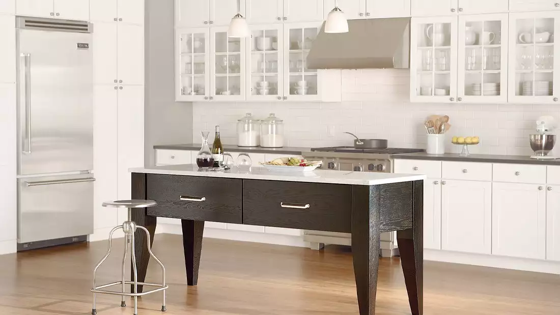 Kitchen with White Cabinets and a Small Island Table with Drawers